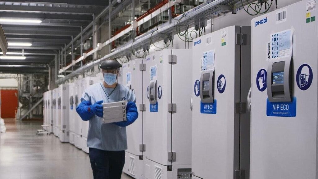 Man with mask holding pharmaceutical boxes